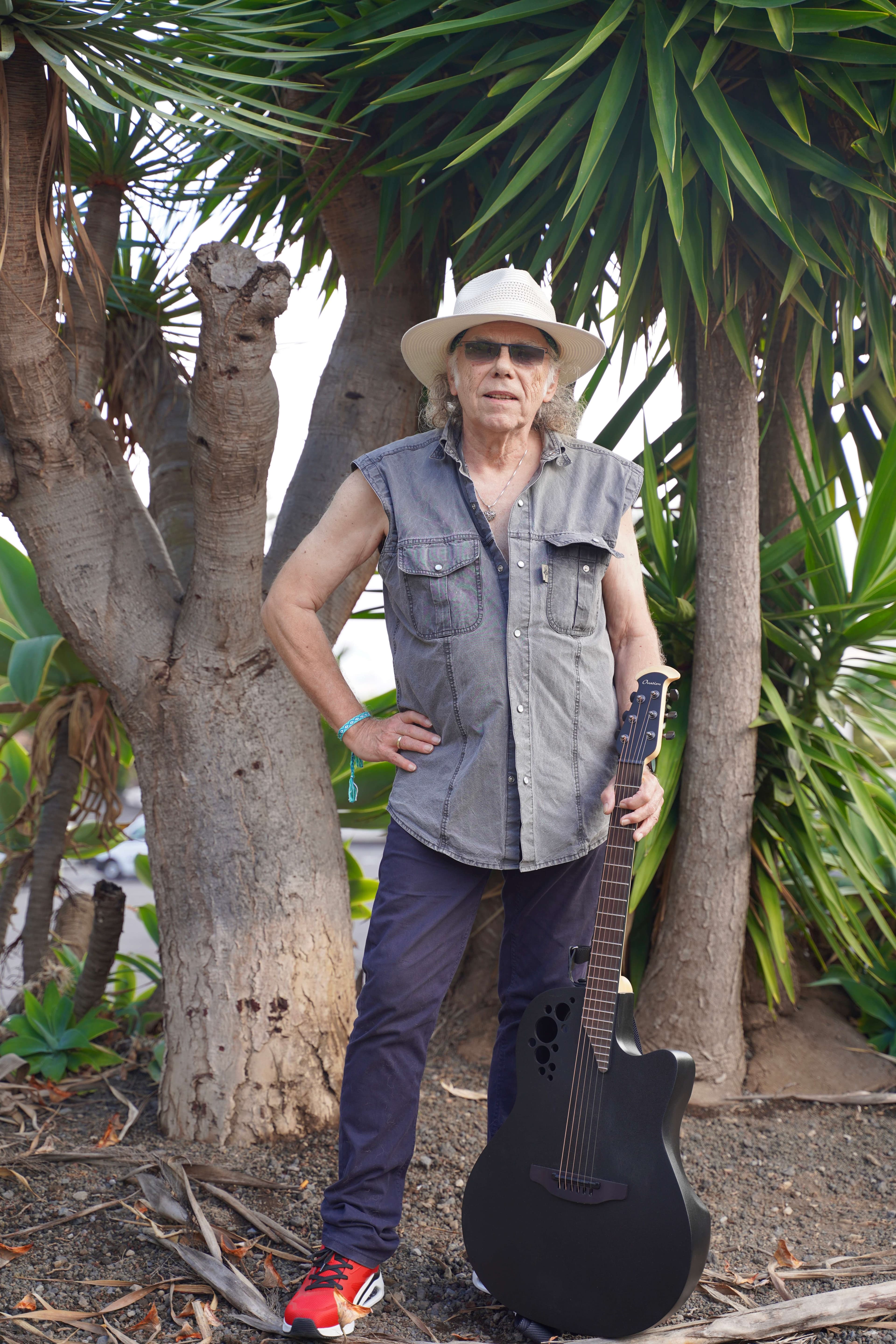 🎶✨ Musical inspiration from Tenerife ✨🎶: a man standing next to a tree holding an acoustic guitar